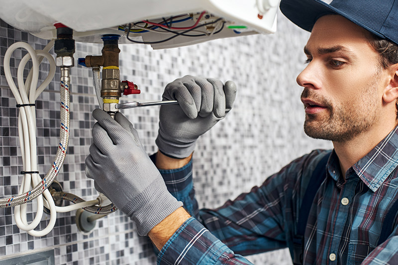 Installation einer Heizungsanlage, Rohr wird befestigt